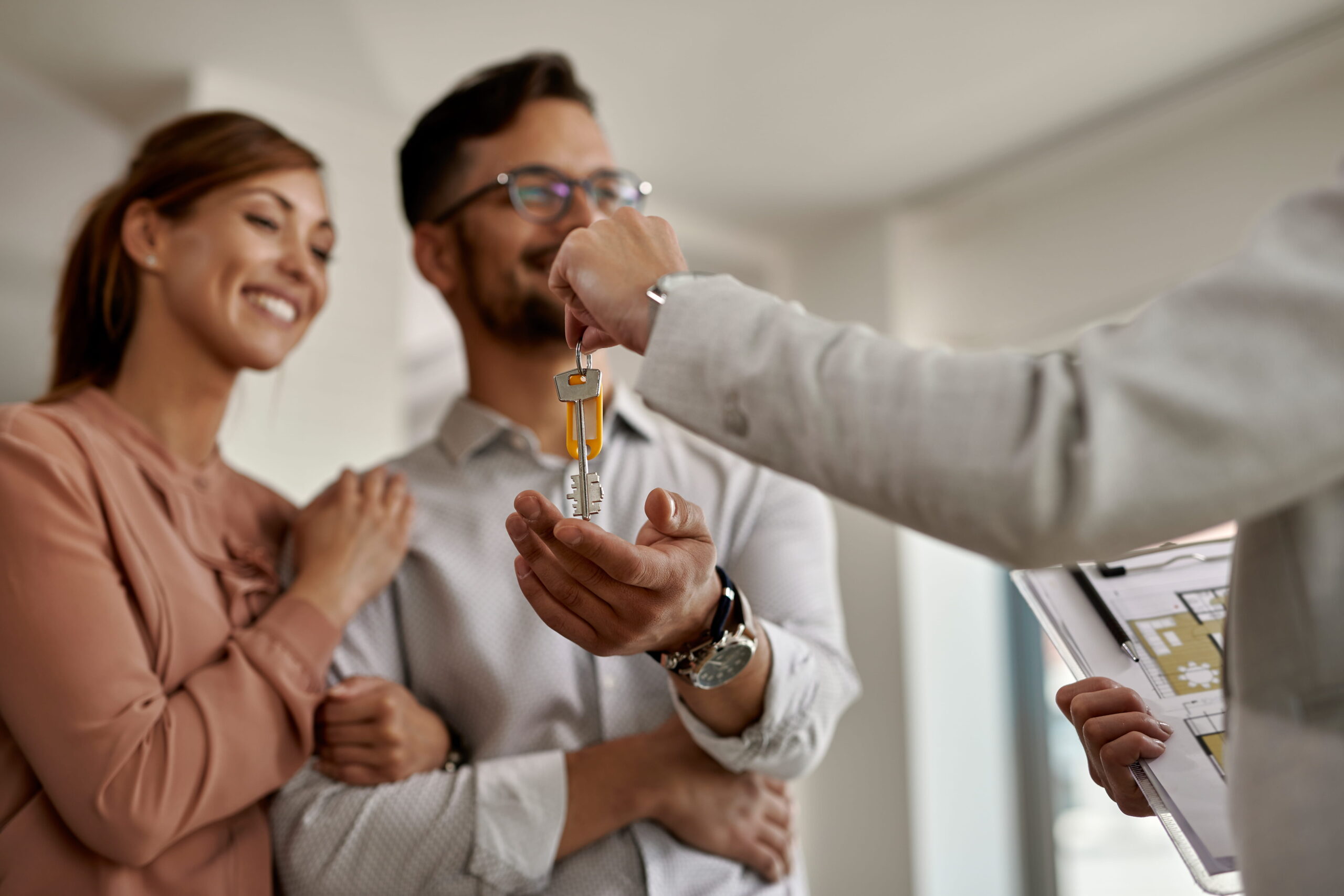 closeup-real-estate-agent-giving-couple-keys-their-new-home (1)